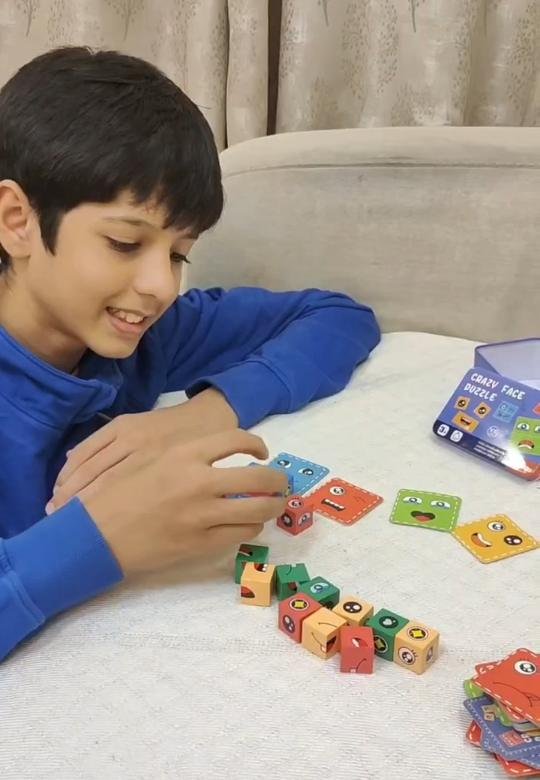 Mikail with the Tukoy crazy face cubes lined up on a table