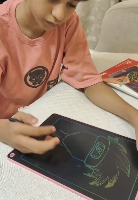 Mikail drawing on the Tukoy LCD writing pad